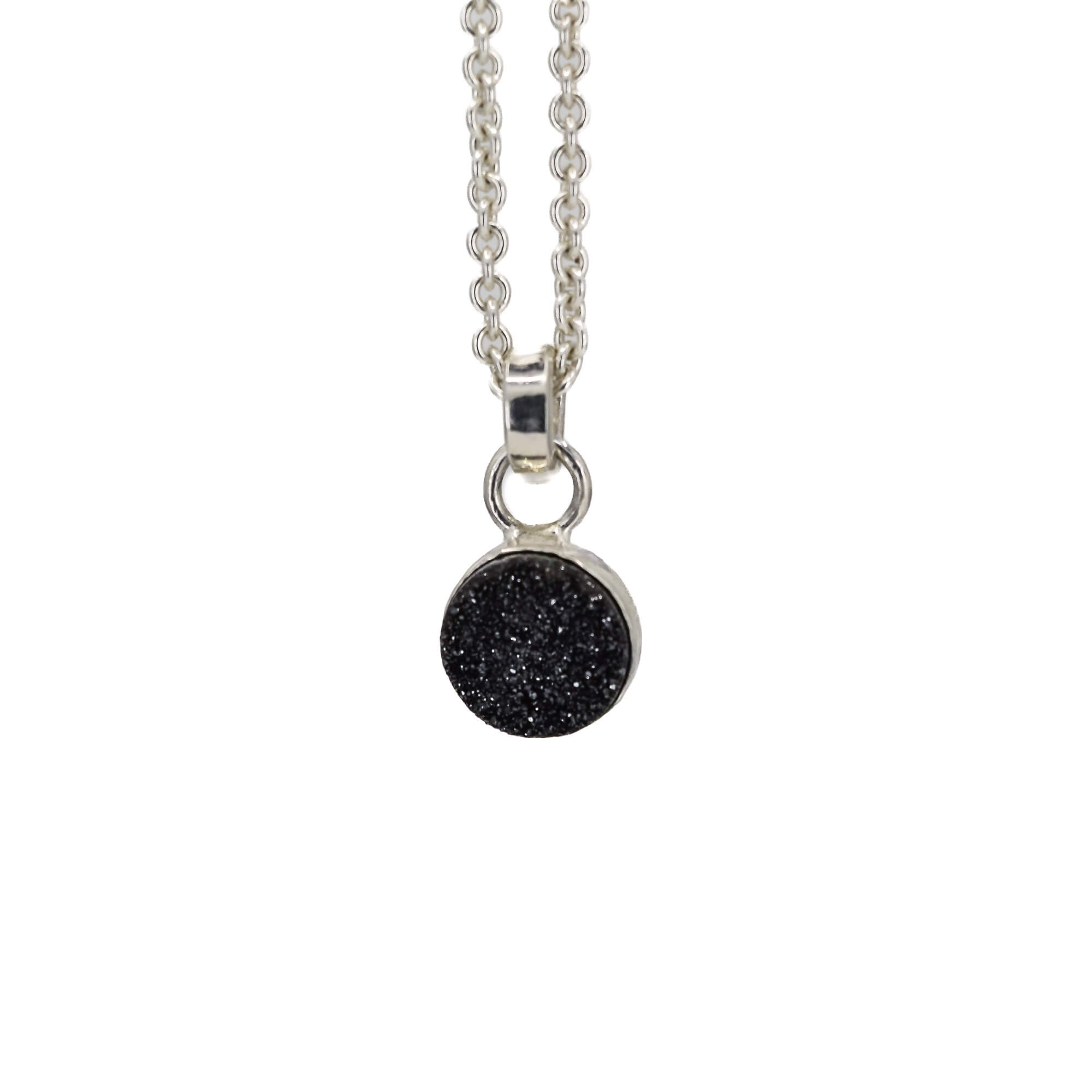 Small round black druzy pendant set in sterling silver hanging on a cable chain