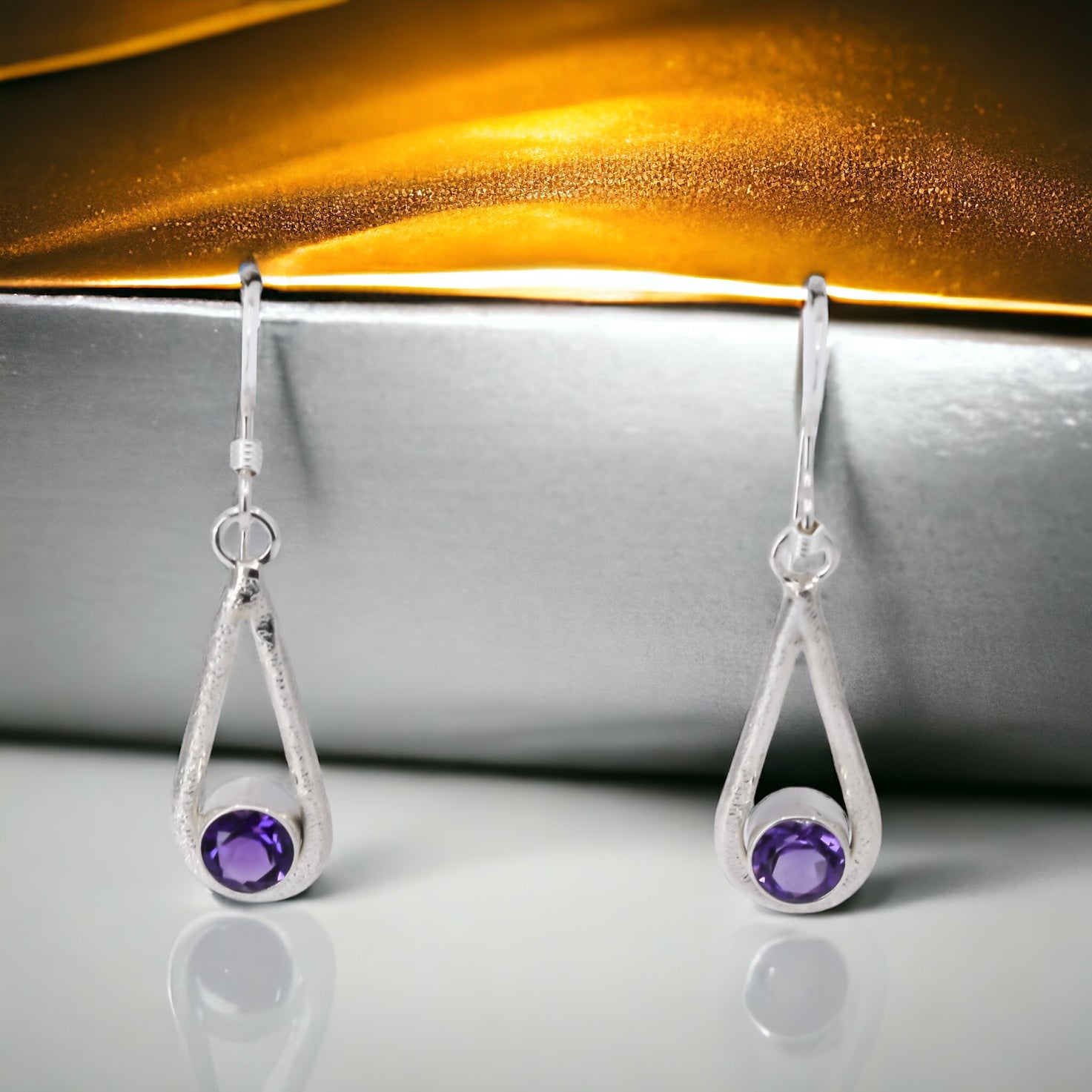 sterling silver textured teardop dangle earrings with round, faceted amethyst stones