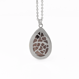 Back of a teardrop amethyst pendant necklace with a random pattern pierced out of the metal. The stone also has sage inclusions at the top, giving it a more natural look.