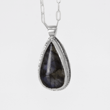 sterling silver pendant with a labradorite stone that has blue flashes hanging from a paperclip style chain