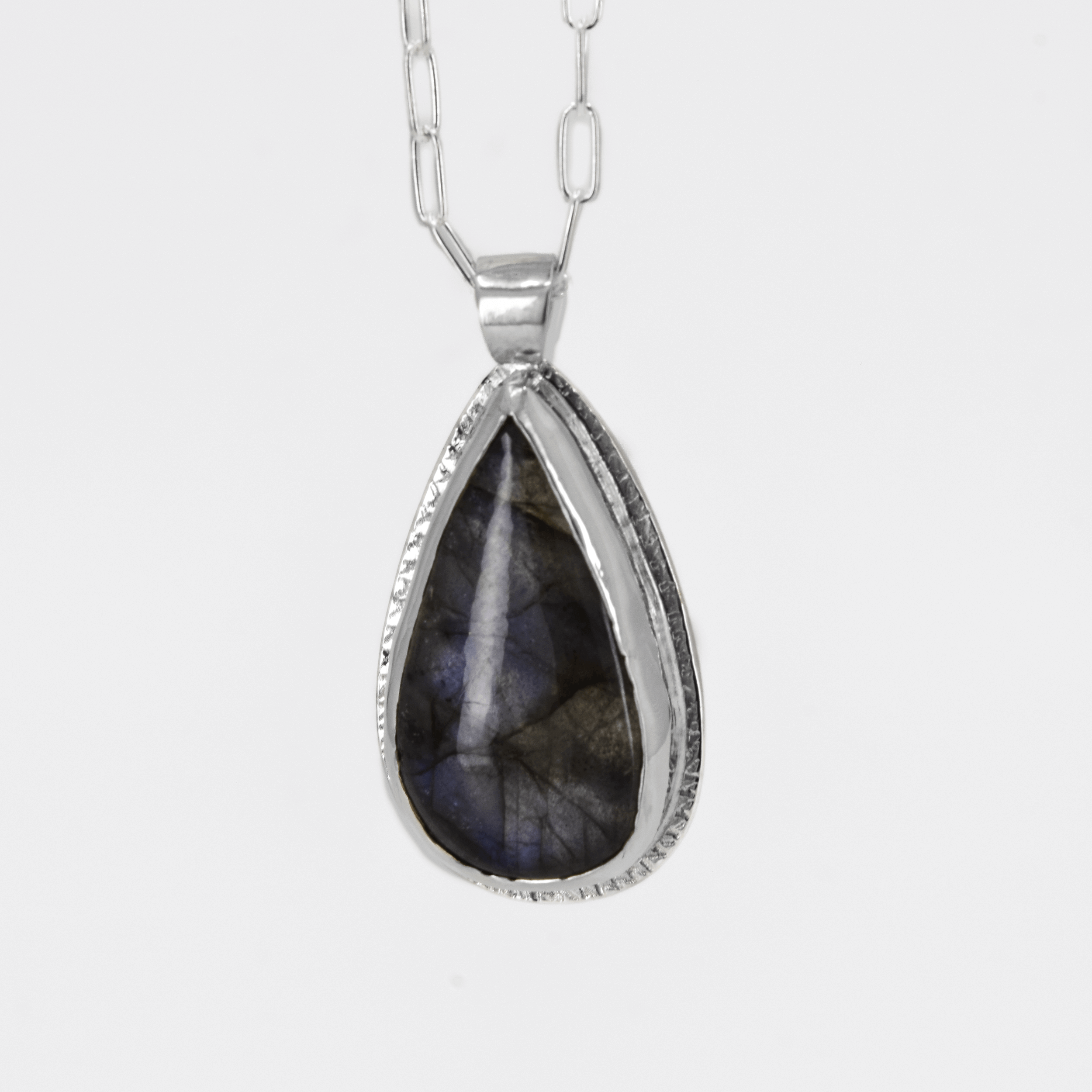 sterling silver pendant with a labradorite stone that has blue flashes hanging from a paperclip style chain