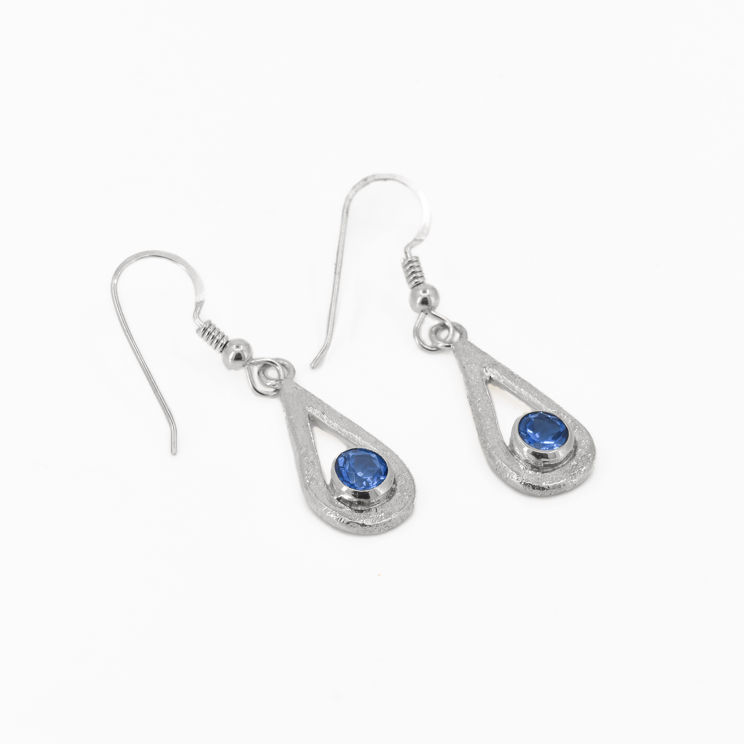 Ice Blue topaz teardrop shaped dangle earrings in sterling silver, featuring a stardust texture.