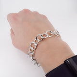 Textured  sterling silver chain link bracelet worn on wrist for scale