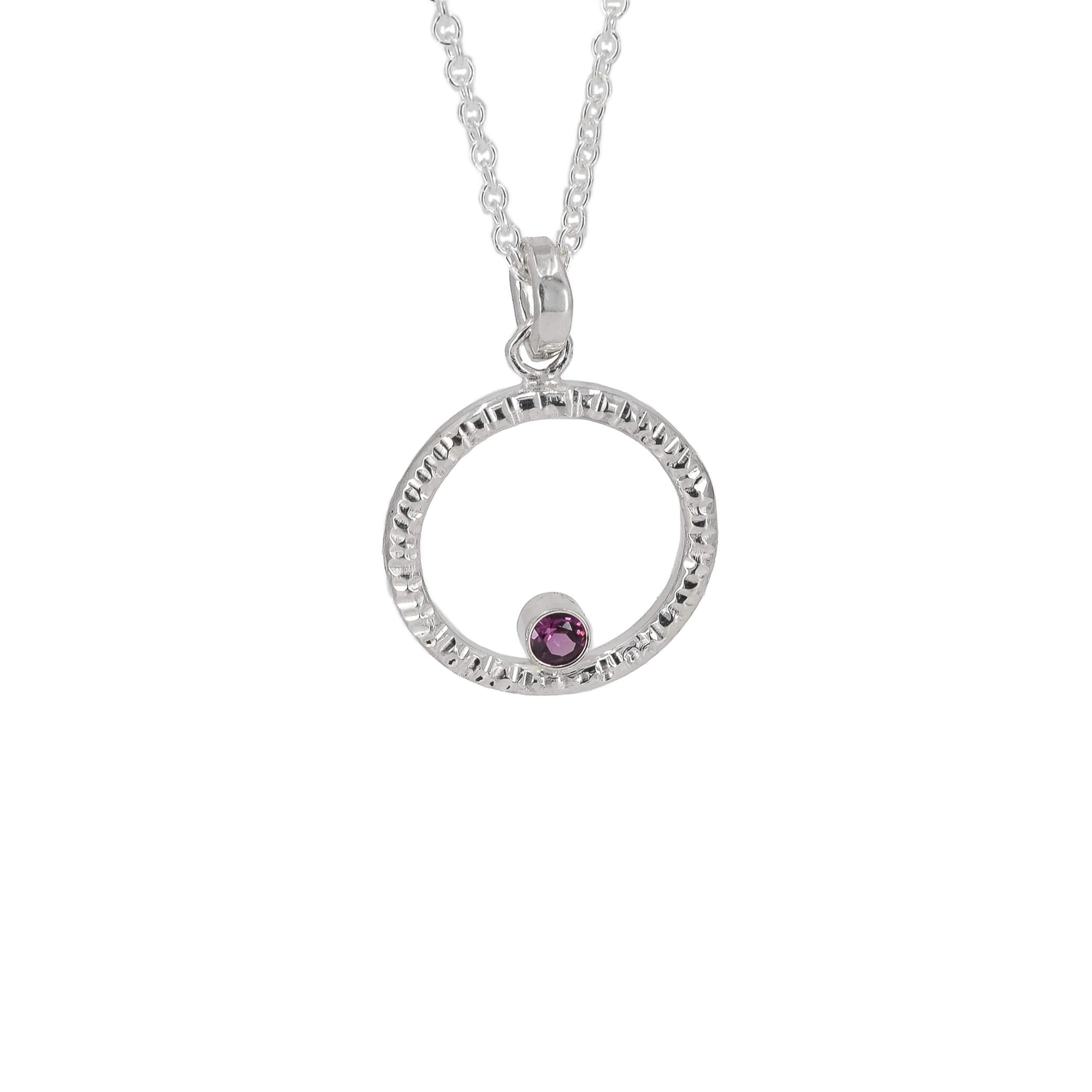 Circle of life pendant necklace in sterling silver with textured edges, featuring a rhodolite garnet faceted stone