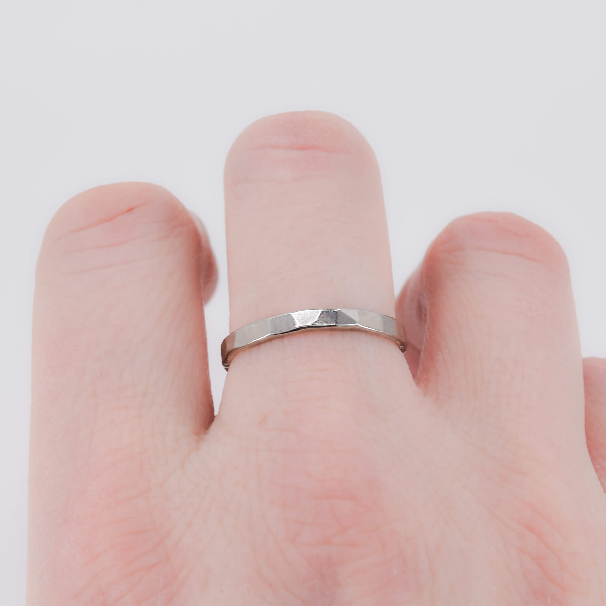 Faceted stacking ring in sterling silver worn on finger