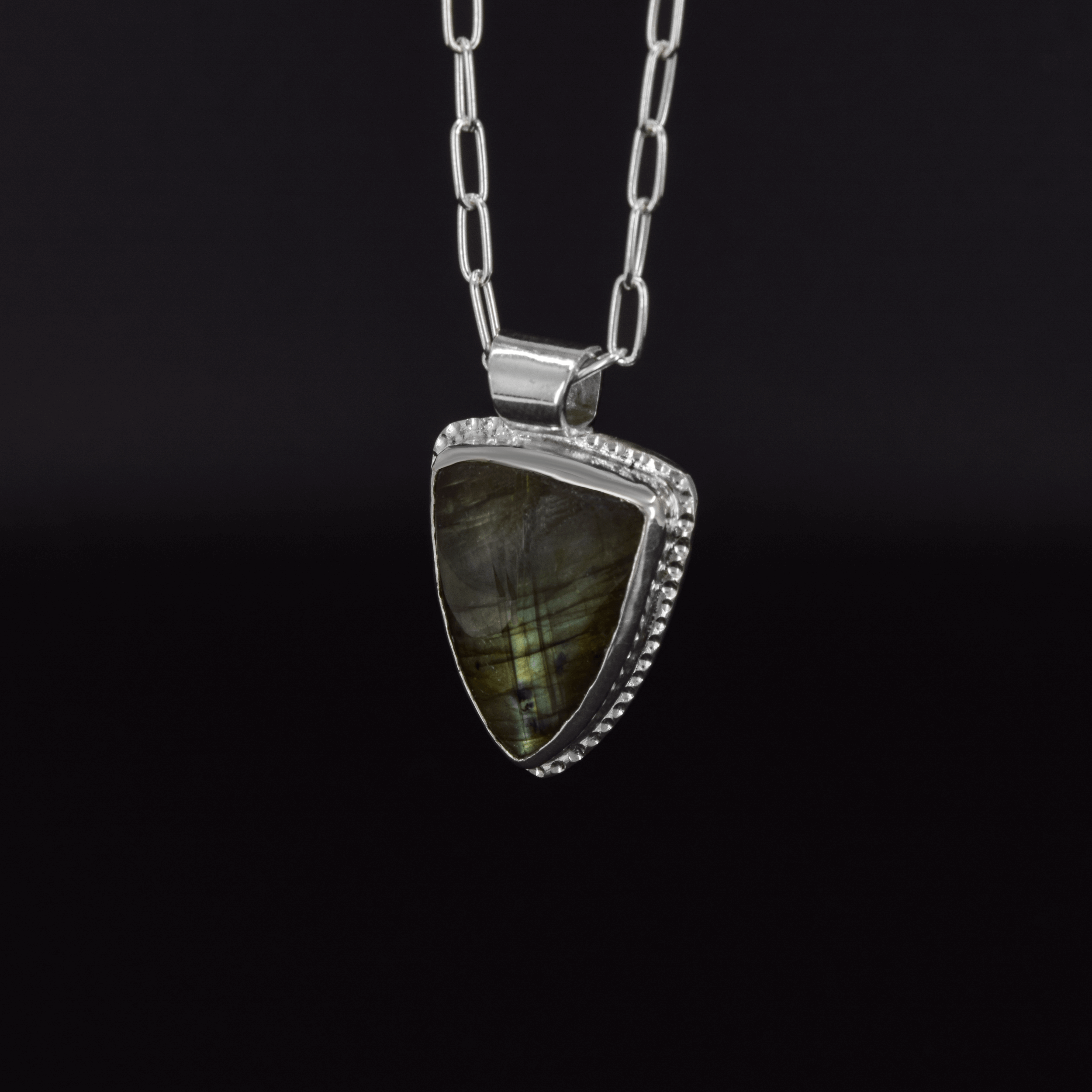 side view of green arrow pendant featuring a green labradorite stone, hanging on a paperclip style chain