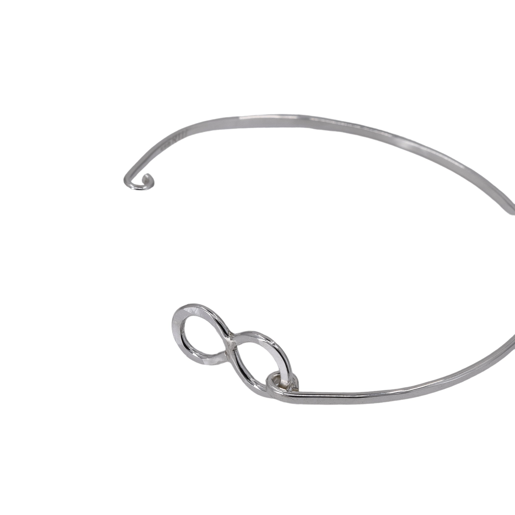 Infinity bangle bracelet in sterling silver with hinged design shown in the open position.