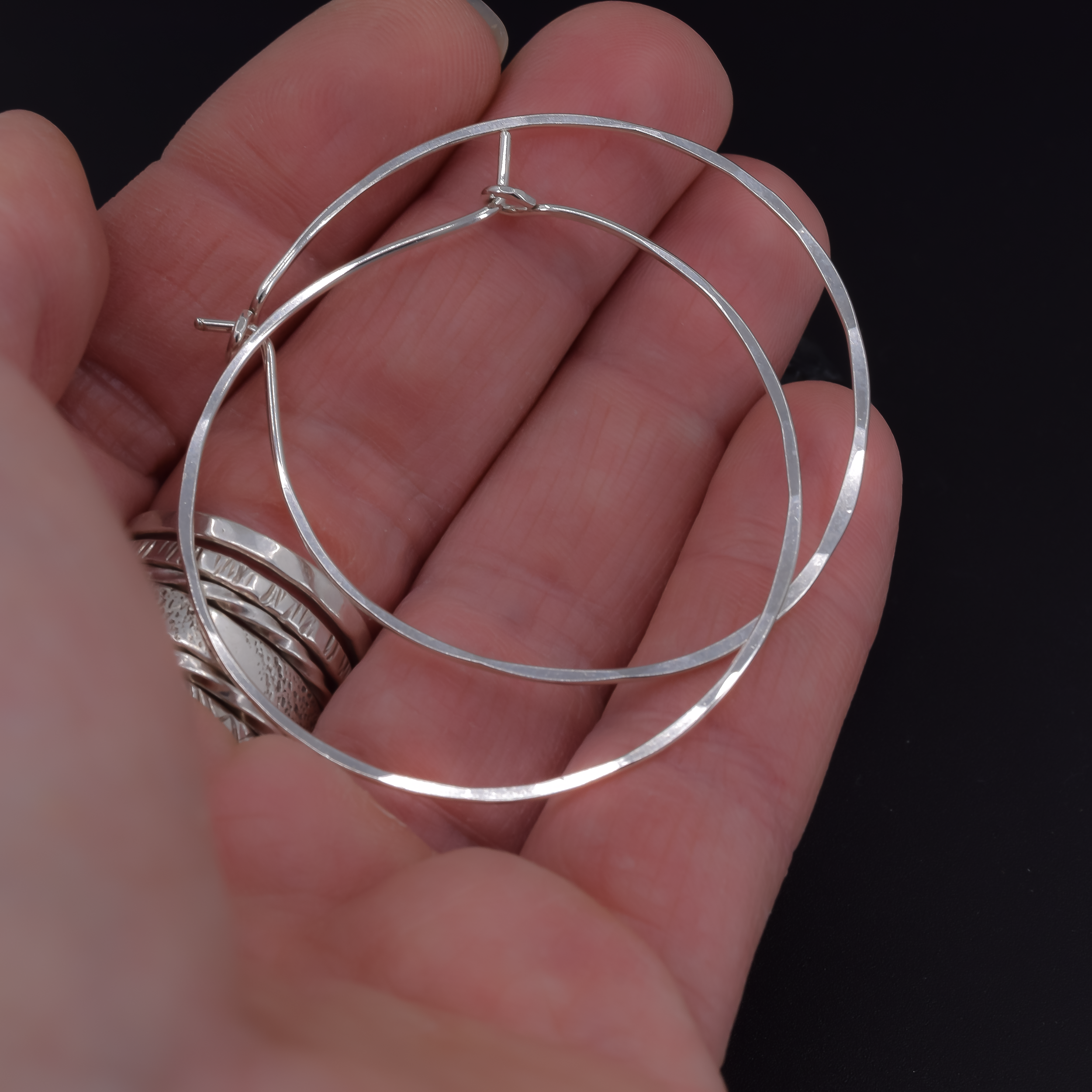Extra large 2 inch sterling silver hoop earrings shown in hand