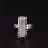 Long rectangular rainbow moonstone sterling silver ring with a hand textured border
