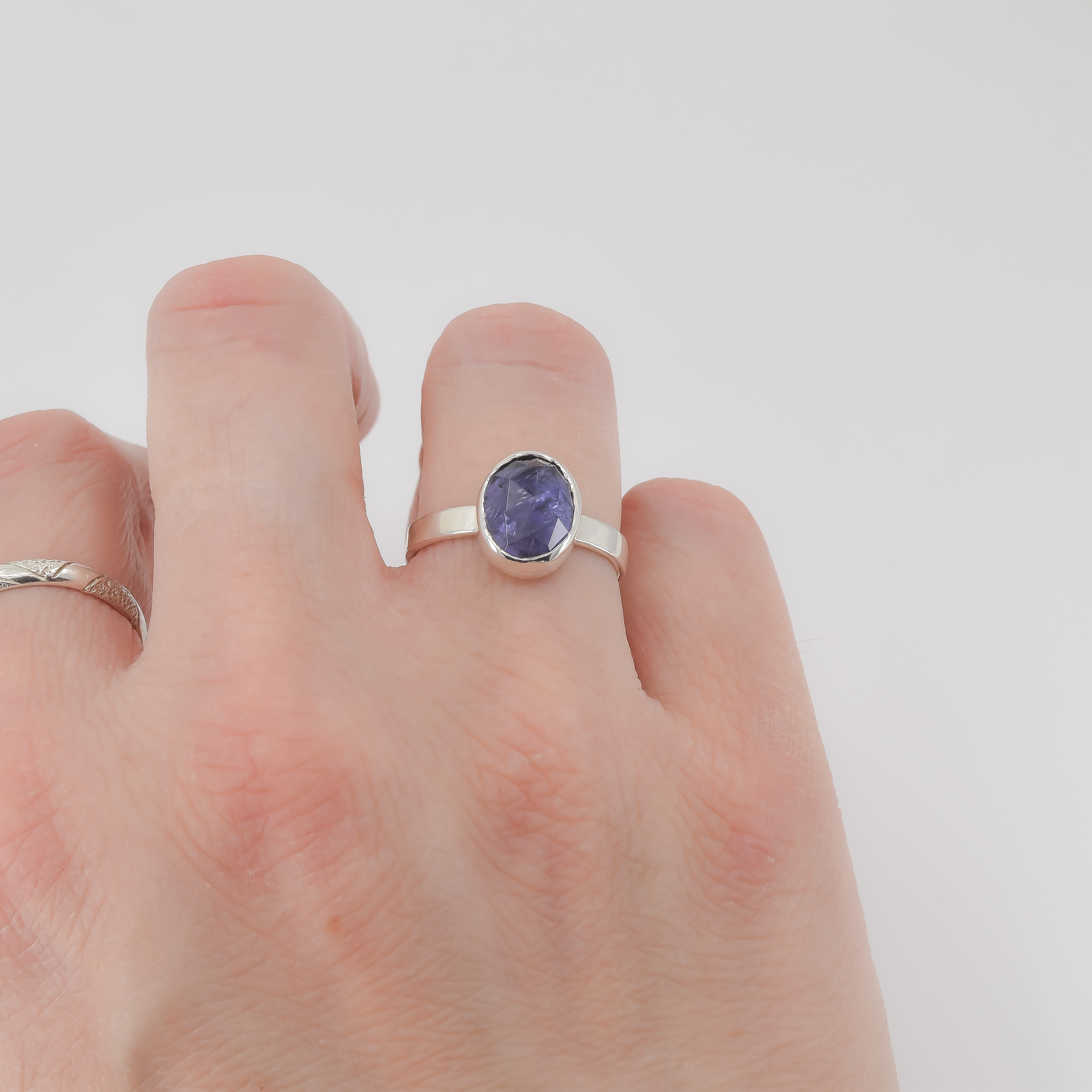 Sterling silver iolite solitaire ring worn on finger