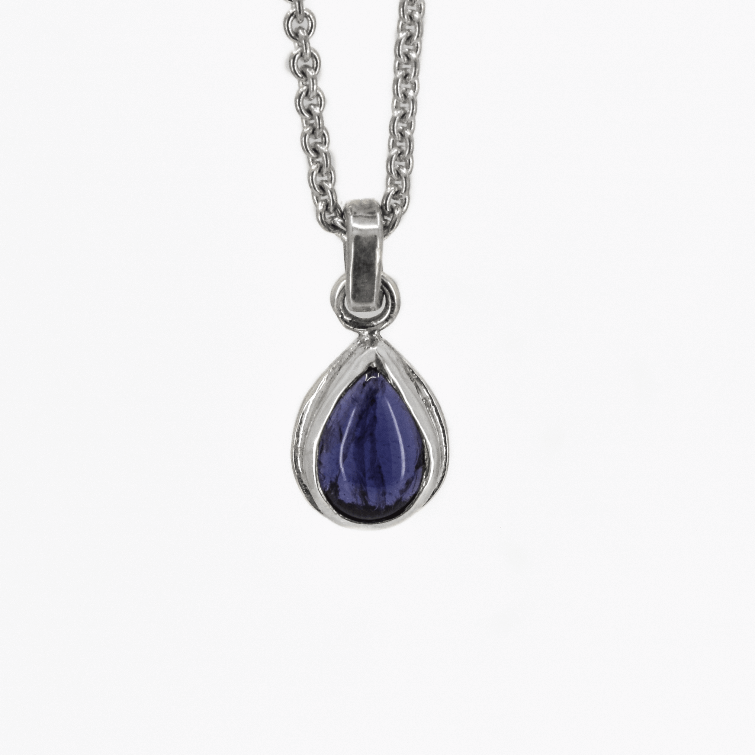 Teardrop shaped iolite pendant necklace in sterling silver hanging on a cable chain