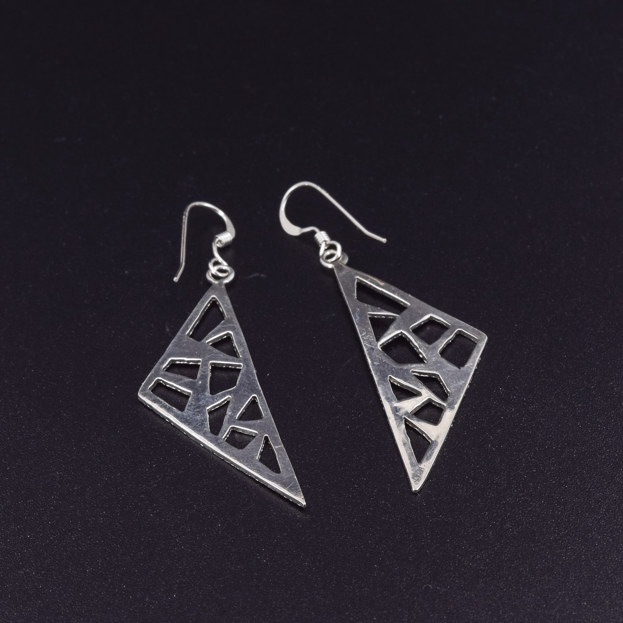 Triangle dangle earrings in sterling silver pierced with a modern design with a polished finish