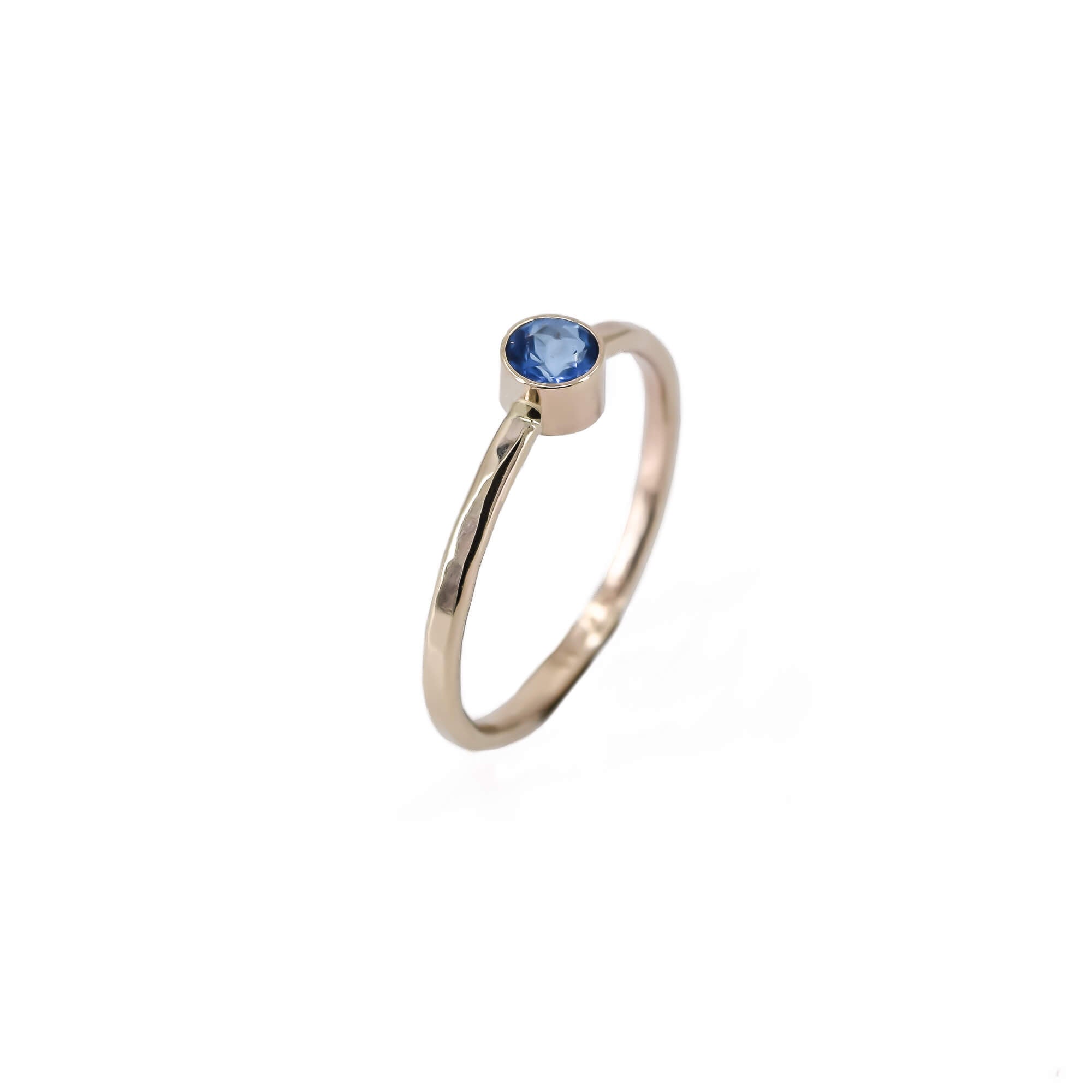 14K yellow gold thin stackable ring with ice blue topaz stone side view