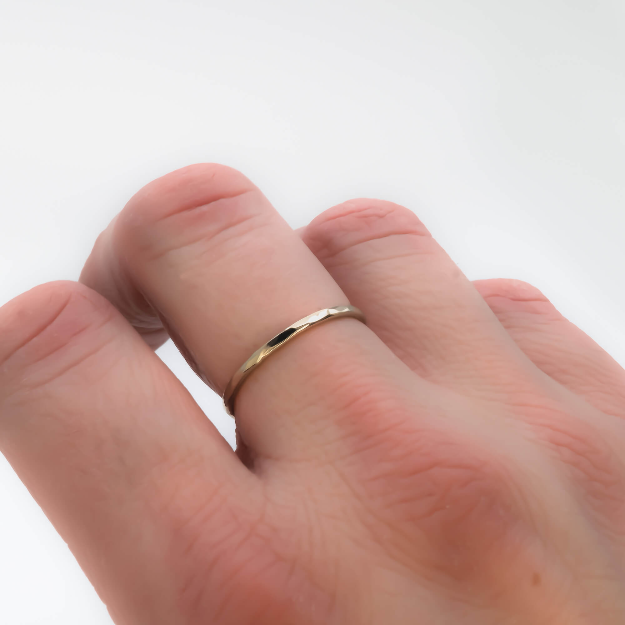 skinny faceted 14K solid gold ring band on hand