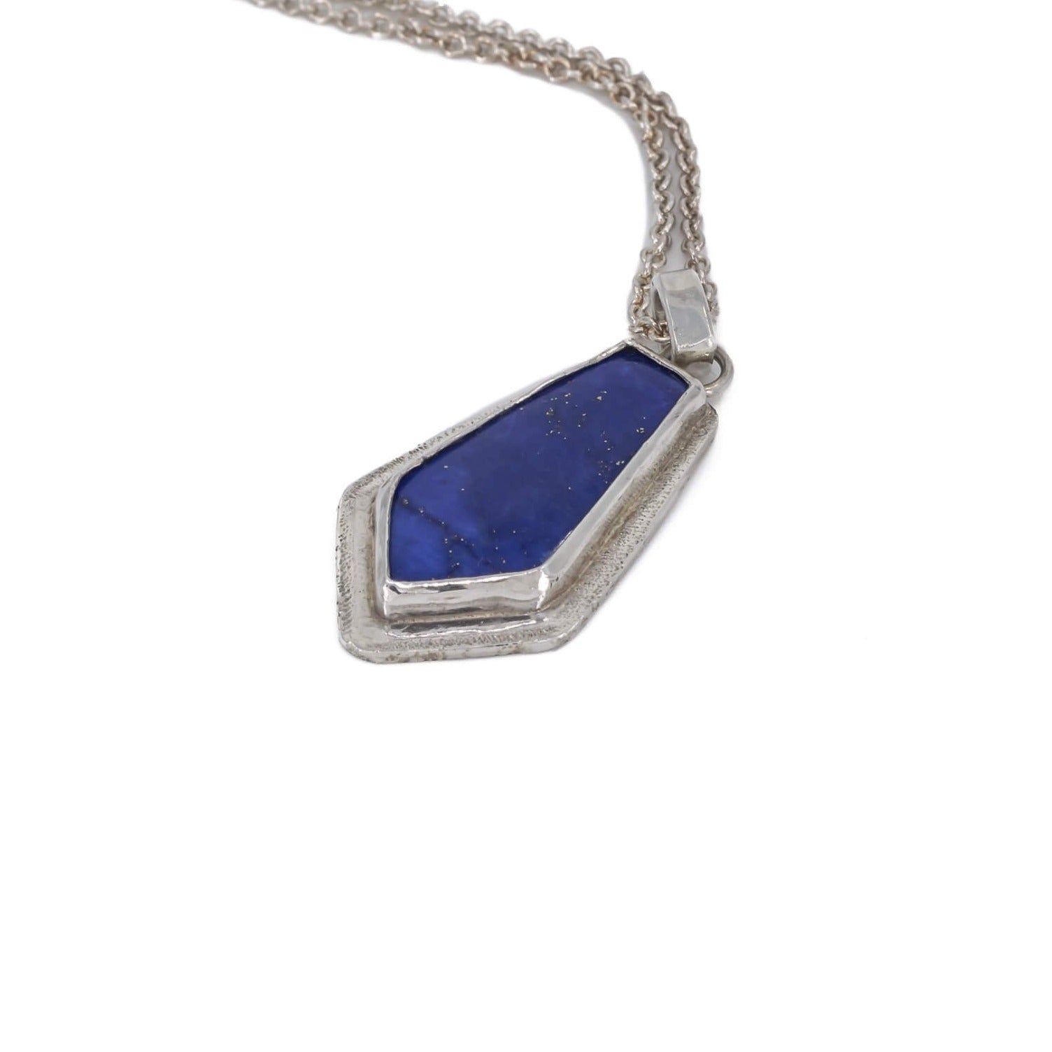 Lapis lazuli kite shaped pendant necklace in sterling silver with a star dust textured border hanging on a cable chain side view