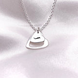Two hearts sterling silver pendant necklace with a hand stamped initial on the smaller heart.
